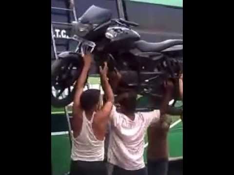 Guy puts #motorcycle on roof of a #bus with his head!