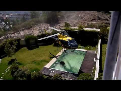 Amazing helicopter pilot taking water from swimming pool