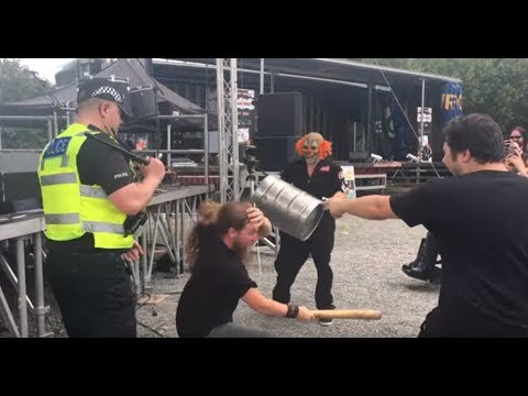Funny fan hitting himself with a baseball bat during a Slipknot cover band performance