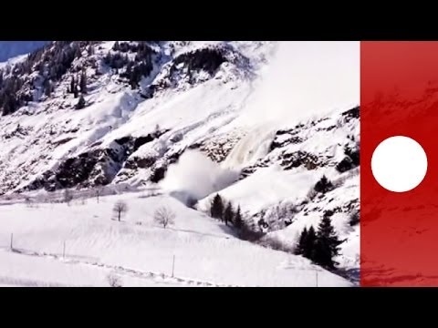 Giant avalanche creeps down Italian alps, narrowly missing houses caught on camera